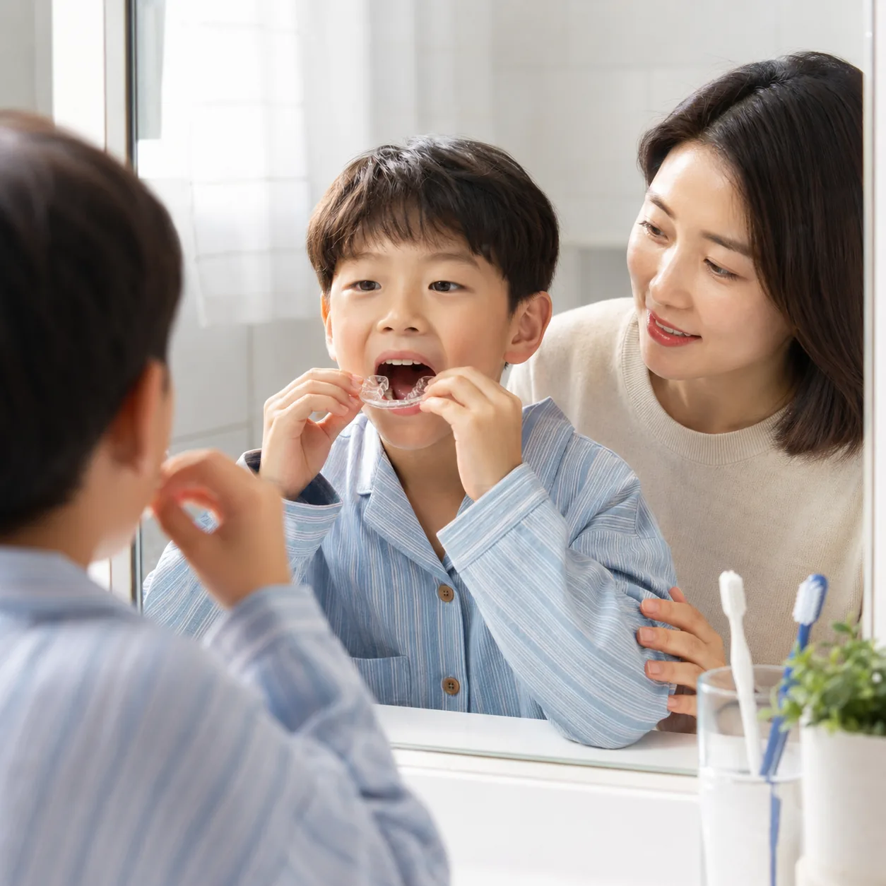 소아 교정 장치 착용을 연습하는 아이와 보호자